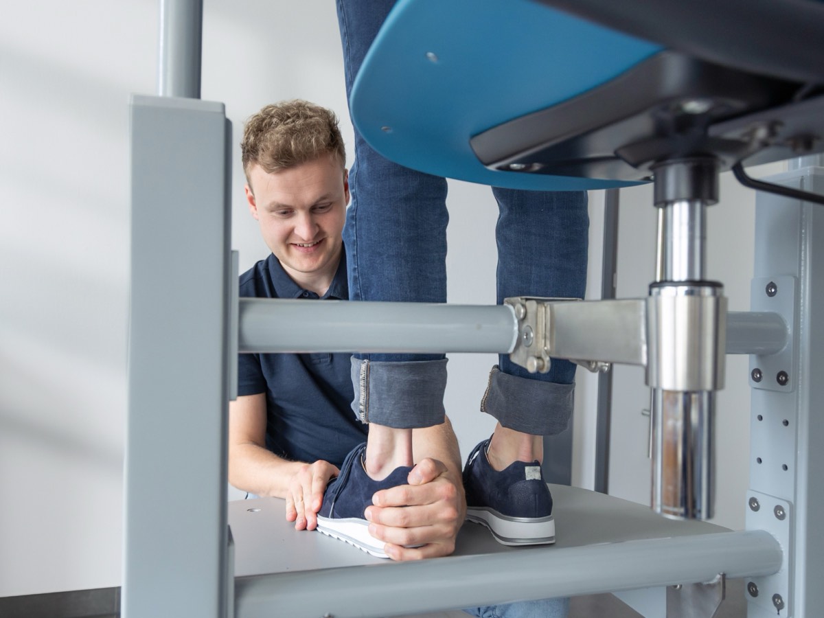 De specialist behandelt de voet rechtop zittend, de onderarmen op het platform en de rug neutraal.